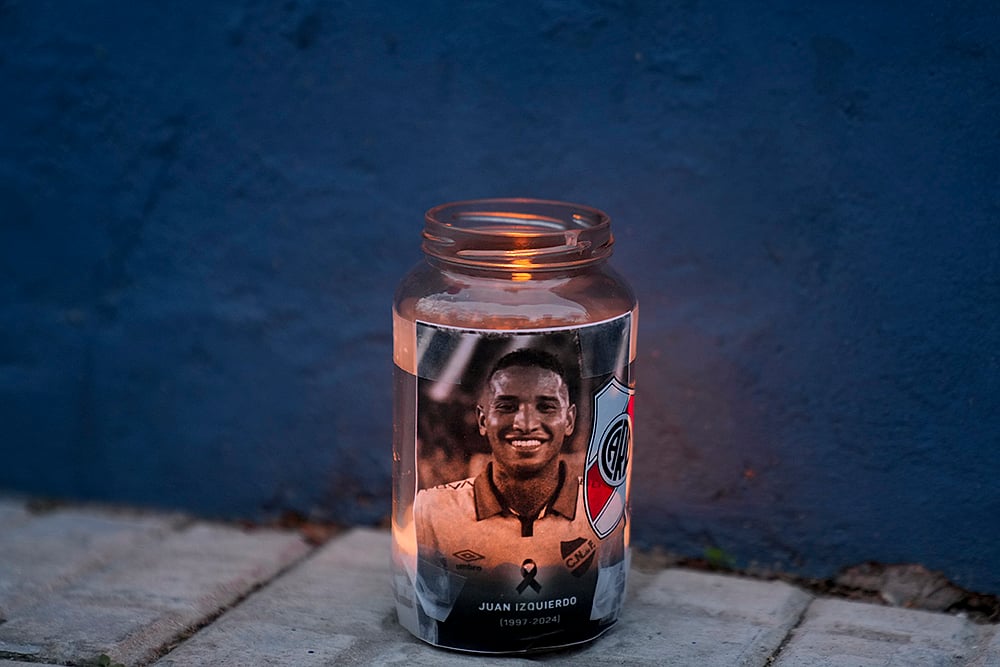 | Photo: AP/Matilde Campodonico : Juan Izquierdo: A candle holder featuring Uruguayan soccer player Juan Izquierdo sits outside the Nacional soccer club in Montevideo